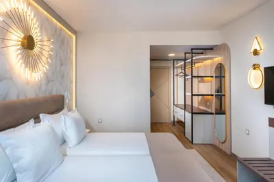 a bedroom with a white bed with a mirror on the wall at Marieta Palace Hotel in Nesebar