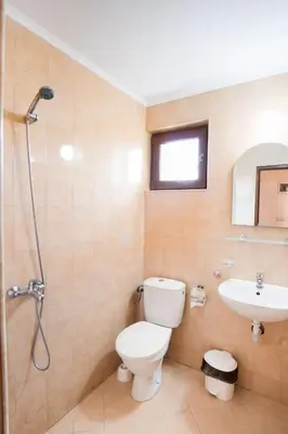 a bathroom with a toilet and a sink at Hotel Zeus in Pomorie