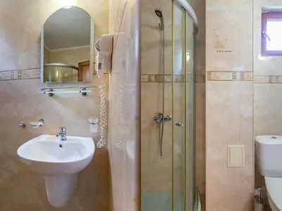 a bathroom with a sink and a shower with a sink at Hotel Zeus in Pomorie