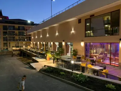 a child standing in front of a building at Paradise Beach Residence - Ultra All Inclusive in Sveti Vlas