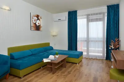 a living room with a blue couch and a table at Paradise Beach Residence - Ultra All Inclusive in Sveti Vlas