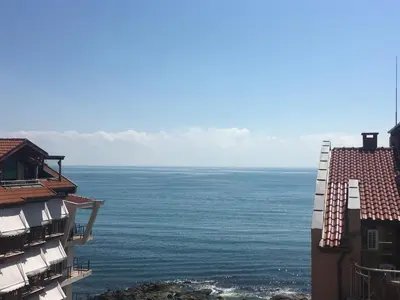 a view of the ocean from between two buildings at Семеен хотел Амон Ра in Sozopol