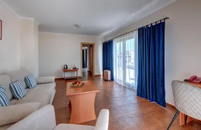 a living room with a couch and a table at Семеен хотел Амон Ра in Sozopol