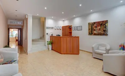 a lobby with two chairs and a counter in a room at Семеен хотел Амон Ра in Sozopol