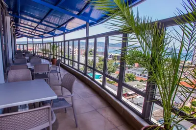 a balcony with tables and chairs and a view of the city at Smartline Meridian Hotel in Sunny Beach