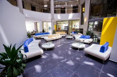 a lobby with couches and tables in a building at Smartline Meridian Hotel in Sunny Beach