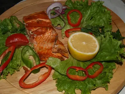 a plate of food with fish and lettuce and a lemon at Victoria Hotel Nessebar in Nesebar
