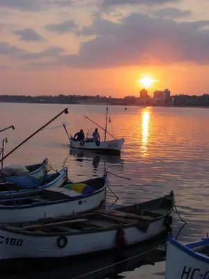 two boats sitting in the water at sunset at Victoria Hotel Nessebar in Nesebar