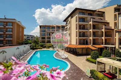 a swimming pool with lounge chairs next to a building at Apartment Tourist Complex Rose Village in Sunny Beach