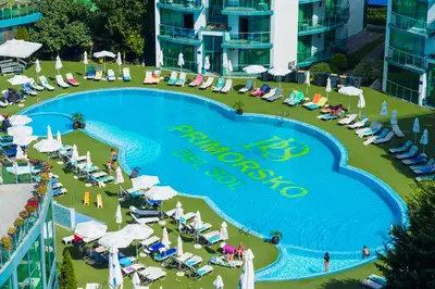 a pool at a resort with chairs and umbrellas at Hotel Primorsko Del Sol in Primorsko