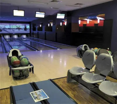 a bowling alley with chairs and a bowling lane at Marina Cape Vacation Complex in Ravda