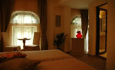 a bedroom with a bed and two windows at Hi Boutique Hotel in Varna City
