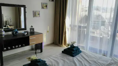 a bedroom with a bed with a dresser and a mirror at Villa Bonita Apartment in Sunny Beach