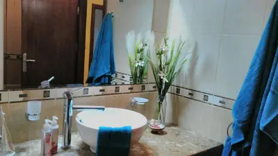 a bathroom with a sink and a vase of flowers at Villa Bonita Apartment in Sunny Beach
