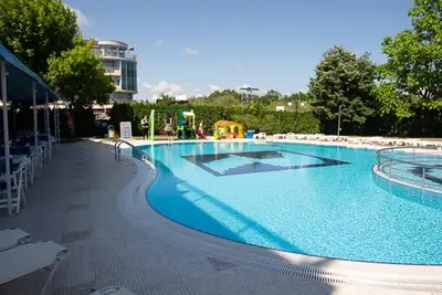 a large swimming pool with a playground in the background at Regata Palace Hotel in Sunny Beach