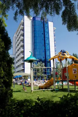a playground in a park with a building in the background at Dunav Hotel in Sunny Beach