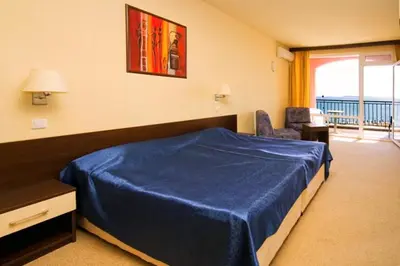 a bedroom with a blue bed and a balcony at Carina Beach in Sunny Beach