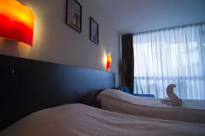 a bedroom with two beds and a stuffed animal sitting on the bed at Tropics Hotel - Ultra All Inclusive in Sveti Vlas