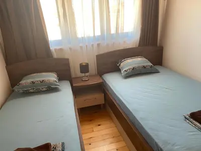two twin beds in a room with a window at Villas Sozopol in Sozopol
