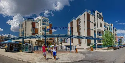 two men are standing in front of a building at Sun City I Apartments in Sunny Beach