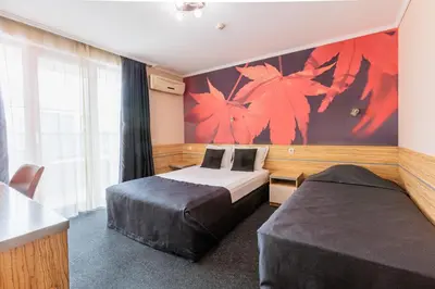 a hotel room with two beds and a large window at Семеен Хотел Опера in Burgas City