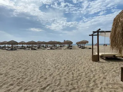 a beach with many chairs and umbrellas on it at Dolce Vita Apartment in Sveti Vlas