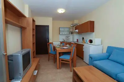 a living room with a blue couch and a kitchen at Sozopol Dreams Apartments in Sozopol