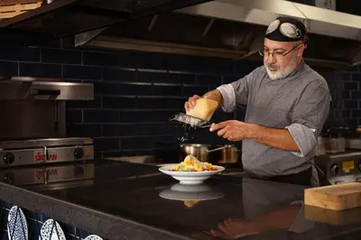 a man in a kitchen preparing a bowl of food at Zefir Hotel in Sunny Beach