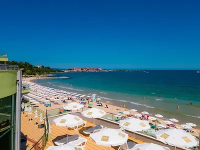 a beach with a bunch of umbrellas and the ocean at MPM Hotel Arsena - Ultra All Inclusive in Nesebar