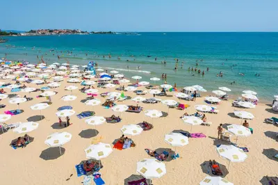 a group of people on a beach with umbrellas at MPM Hotel Arsena - Ultra All Inclusive in Nesebar