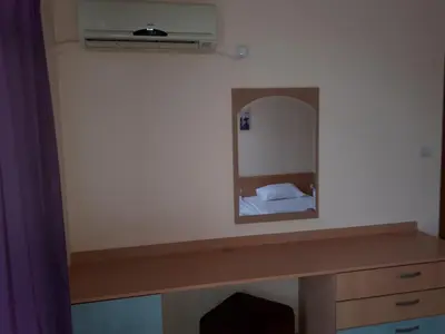 a mirror above a desk with a bed in a room at Apart Hotel Ravda in Ravda