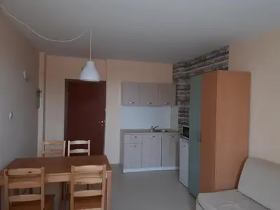 a kitchen with a table and a kitchen with a refrigerator at Apart Hotel Ravda in Ravda