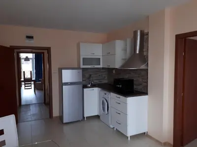 a kitchen with a white refrigerator and a dishwasher at Apart Hotel Ravda in Ravda