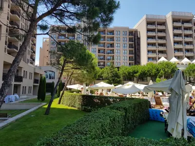 a resort with tables and umbrellas and buildings at Barcelo SeaView Apartment in Sunny Beach