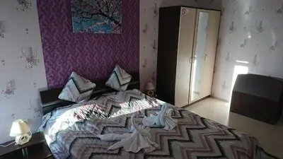 a bedroom with a large bed with a purple wall at Apartment Sianie в центъра на Слънчев бряг, само на няколко крачки от плажа in Sunny Beach