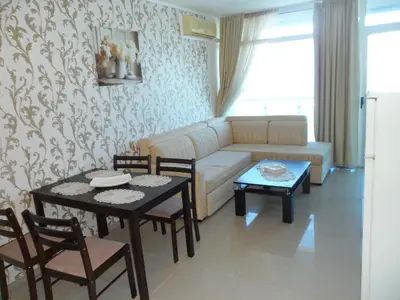 a living room with a couch and a table and chairs at Apartment Sianie в центъра на Слънчев бряг, само на няколко крачки от плажа in Sunny Beach
