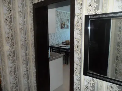 a mirror on the wall of a room with a table at Apartment Sianie в центъра на Слънчев бряг, само на няколко крачки от плажа in Sunny Beach