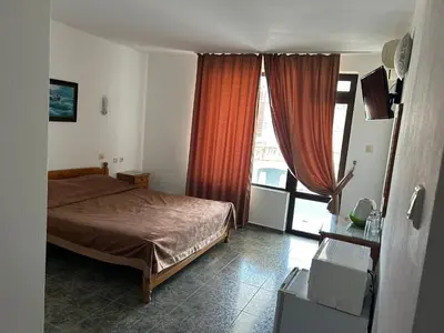 a bedroom with a bed and a large window at КЪЩА