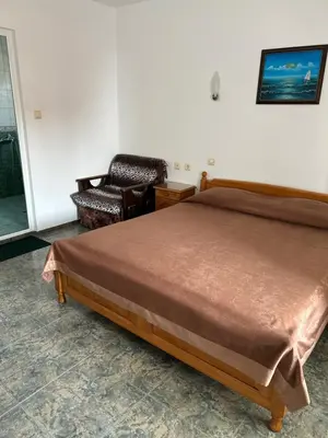 a bedroom with a bed and a chair in it at КЪЩА