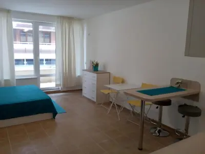 a bedroom with a bed and a desk and a table at Studio Zlatina in Pomorie