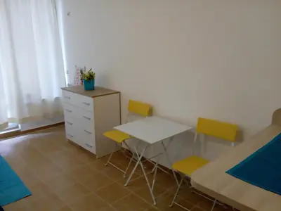 a room with a table and chairs and a dresser at Studio Zlatina in Pomorie