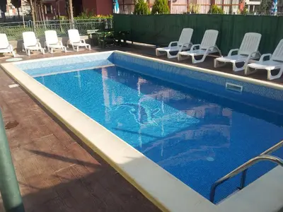a swimming pool with white chairs and a swimming pool at Family Hotel Romantik in Sunny Beach
