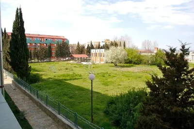 a view of a park with a building and trees at Family Hotel Romantik in Sunny Beach