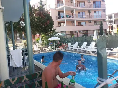 a man standing in a swimming pool with bottles of beer at Family Hotel Romantik in Sunny Beach