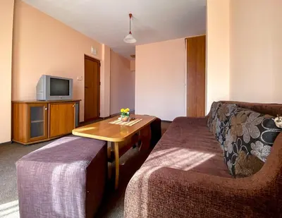 a room with a couch and a table and a tv at Vanessa Family Hotel in Ravda
