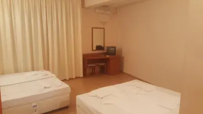 a room with two beds and a desk with a mirror at Hotel Seasons 2 in Sunny Beach