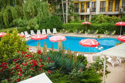 a swimming pool with umbrellas and chairs and a hotel at Deva Hotel - All Inclusive in Sunny Beach