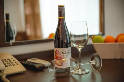 a bottle of wine and a glass on a table at Deva Hotel - All Inclusive in Sunny Beach