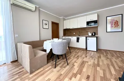 a living room with a table and a couch and a kitchen at Sineva Del Sol Apartments in Sveti Vlas