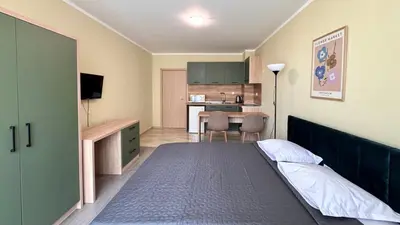 a small bedroom with a bed and a kitchen at Evi Apartments 2 in Pomorie
